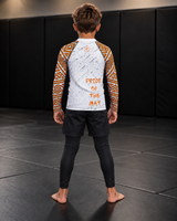 Roll Gear Lion’s Pride Long Sleeve Rash Guard – White & Gold – Kids, back view on a boy.