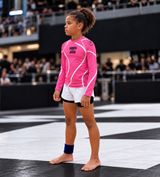 Roll Gear Kids Pink Long Sleeve Rash Guard, young girl walking onto a competition mat.