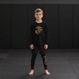 Roll Gear Kids Marines “Gold” Compression Spats – Black & Gold USMC, worn by a young athlete on the mat.