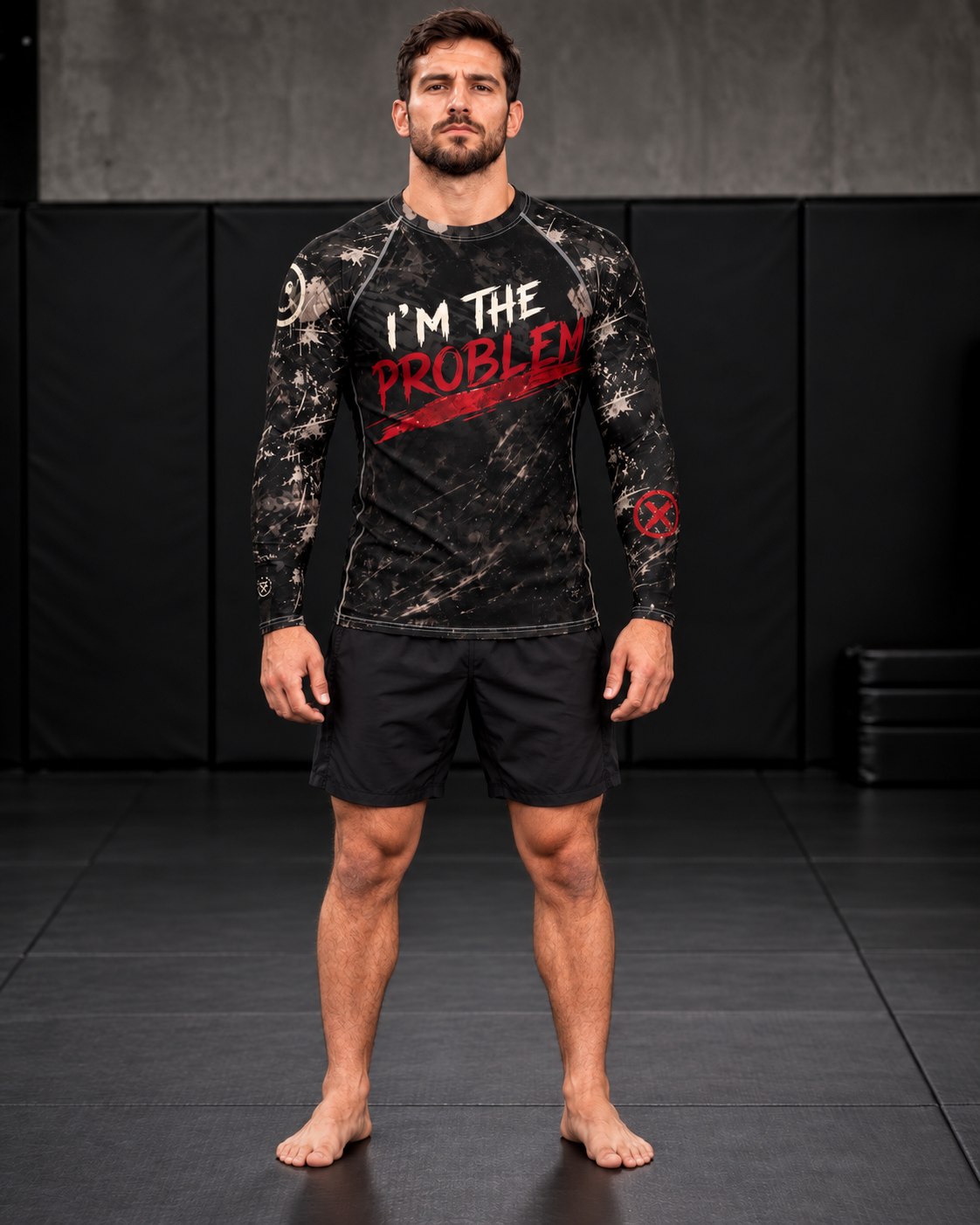 Men's I'm the Problem long sleeve rash guard by Roll Gear, black distressed camo print with white and red brush-lettered graphic, worn by male grappler on mats
