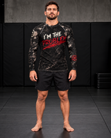 Men's I'm the Problem long sleeve rash guard by Roll Gear, black distressed camo print with white and red brush-lettered graphic, worn by male grappler on mats