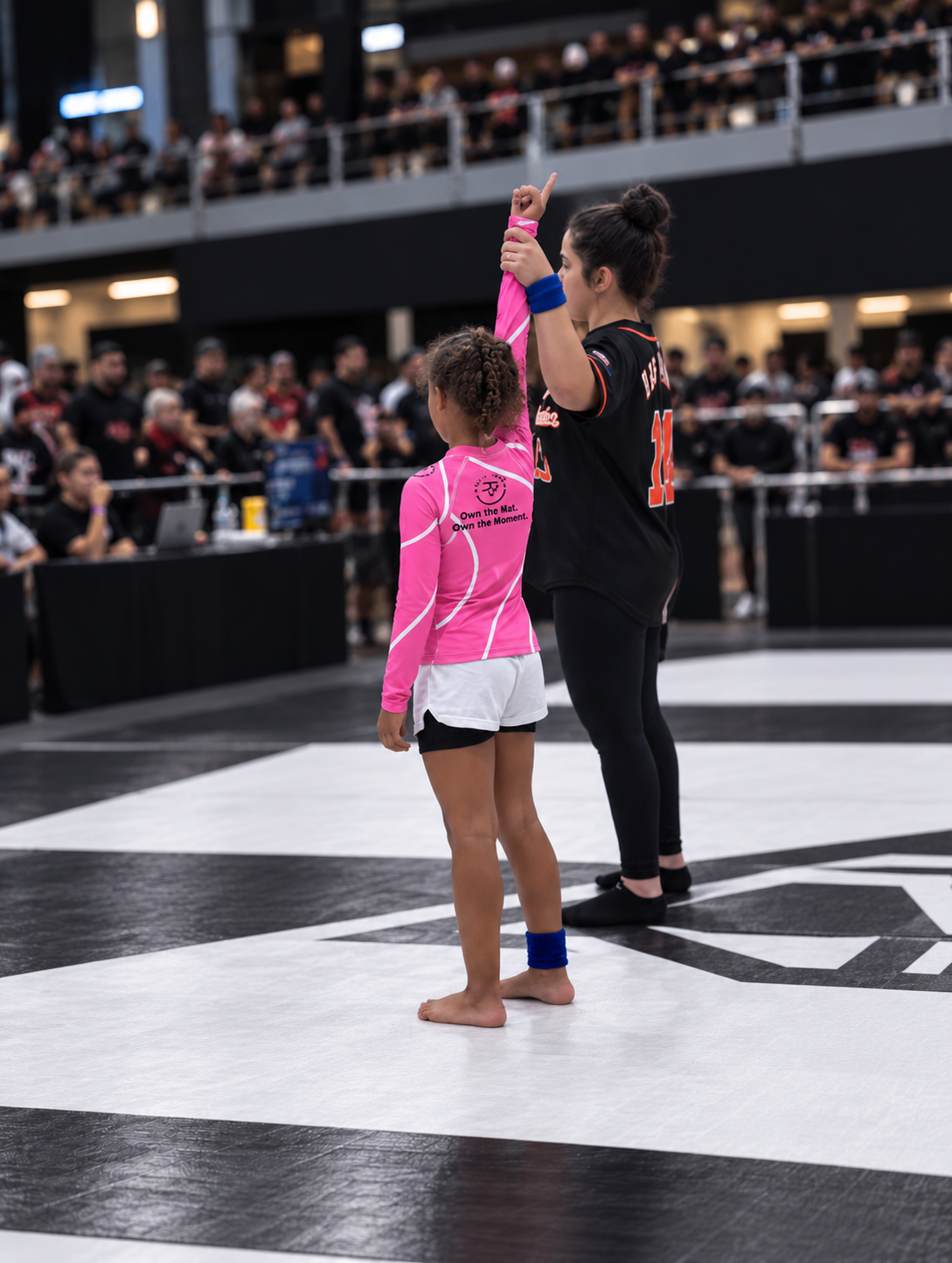 Roll Gear Kids Pink Long Sleeve Rash Guard, young girl getting her hand raised by the referee.