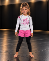 Roll Gear Tap Hype Girls on the Mat Rash Guard – Light Pink/White – Kids Long Sleeve, front view on a young girl.