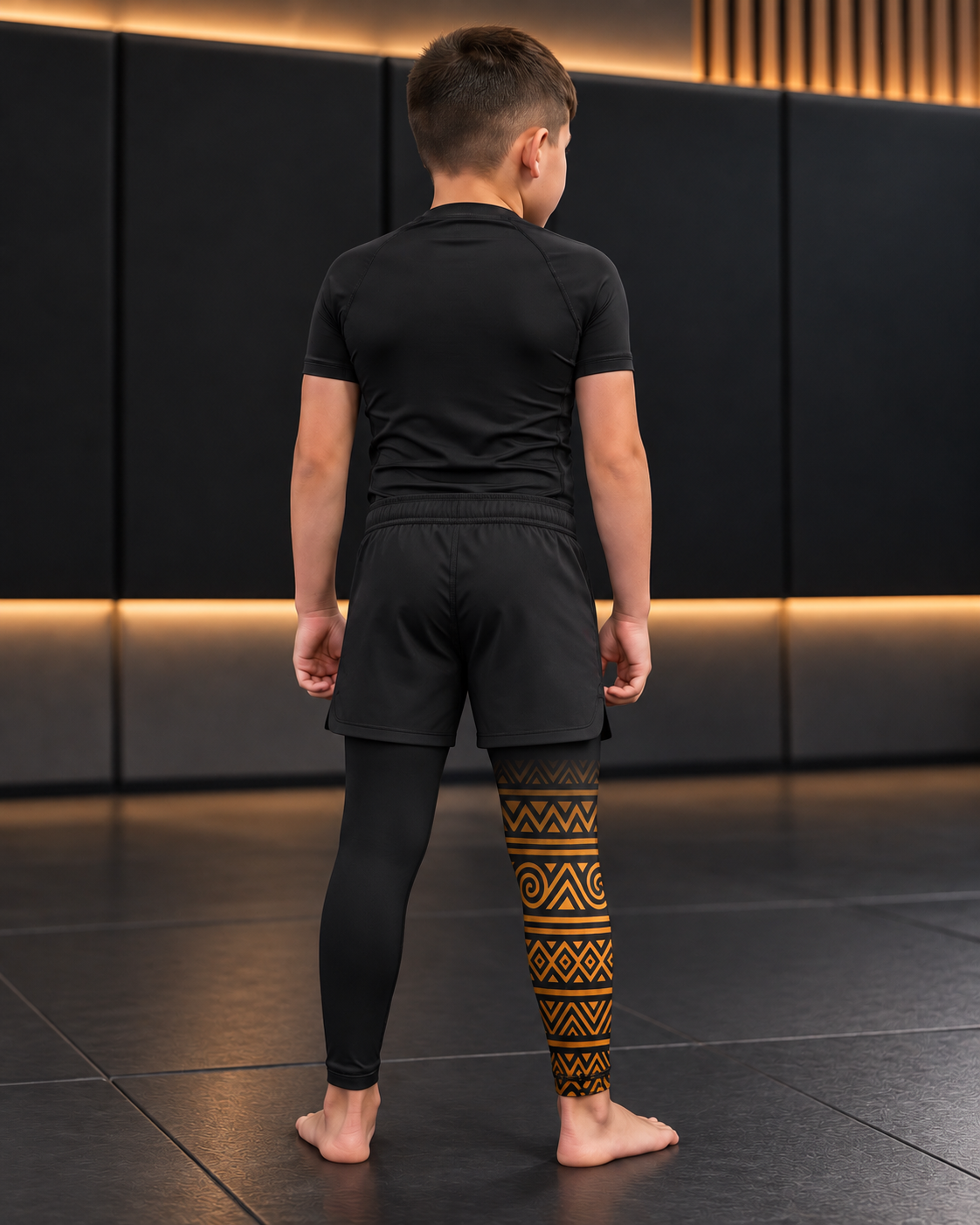 Roll Gear Lion's Pride Kids BJJ Spats – Black & Gold, back view on a boy.
