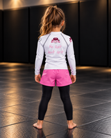 Roll Gear Tap Hype Girls on the Mat Rash Guard – Light Pink/White – Kids Long Sleeve, back view on a young girl.