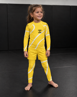Roll Gear Yellow Swirl Spats – Yellow/White – Kids, front view on a young girl in the matching rash guard.