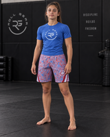Roll Gear Stars & Scribbles Grappling Shorts – Girls', girl standing in an academy, front view.