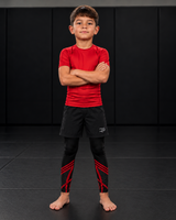 Roll Gear Kids Marines Dress Blues Compression Spats, worn under shorts by a young athlete on the mat.