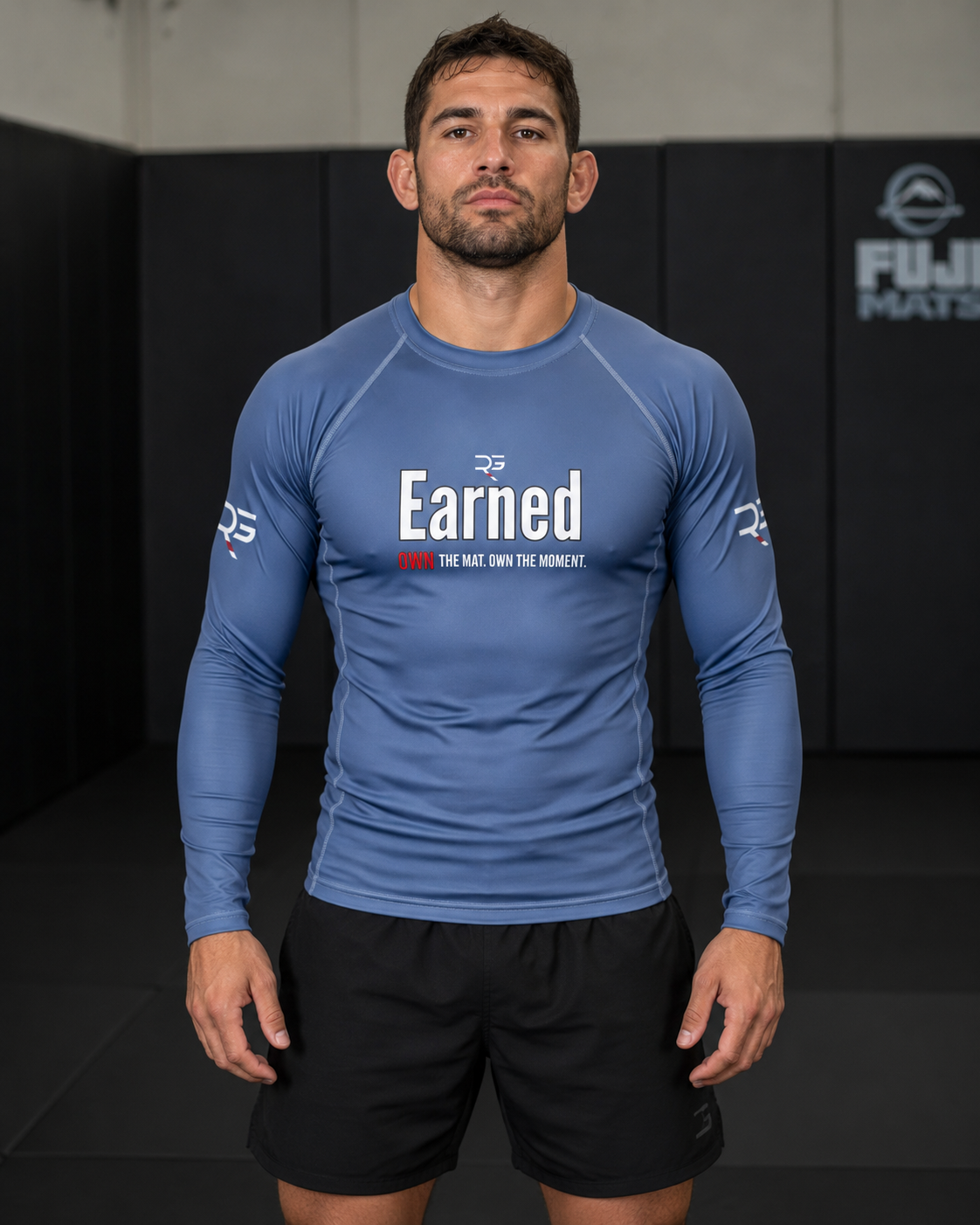 Roll Gear Earned Not Given Long Sleeve Rash Guard – Blue – Men’s, front view on a model in an academy.