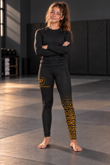 Roll Gear Lion's Pride Spats – Black & Gold – Youth, gold tribal leg pattern, worn by a young athlete.