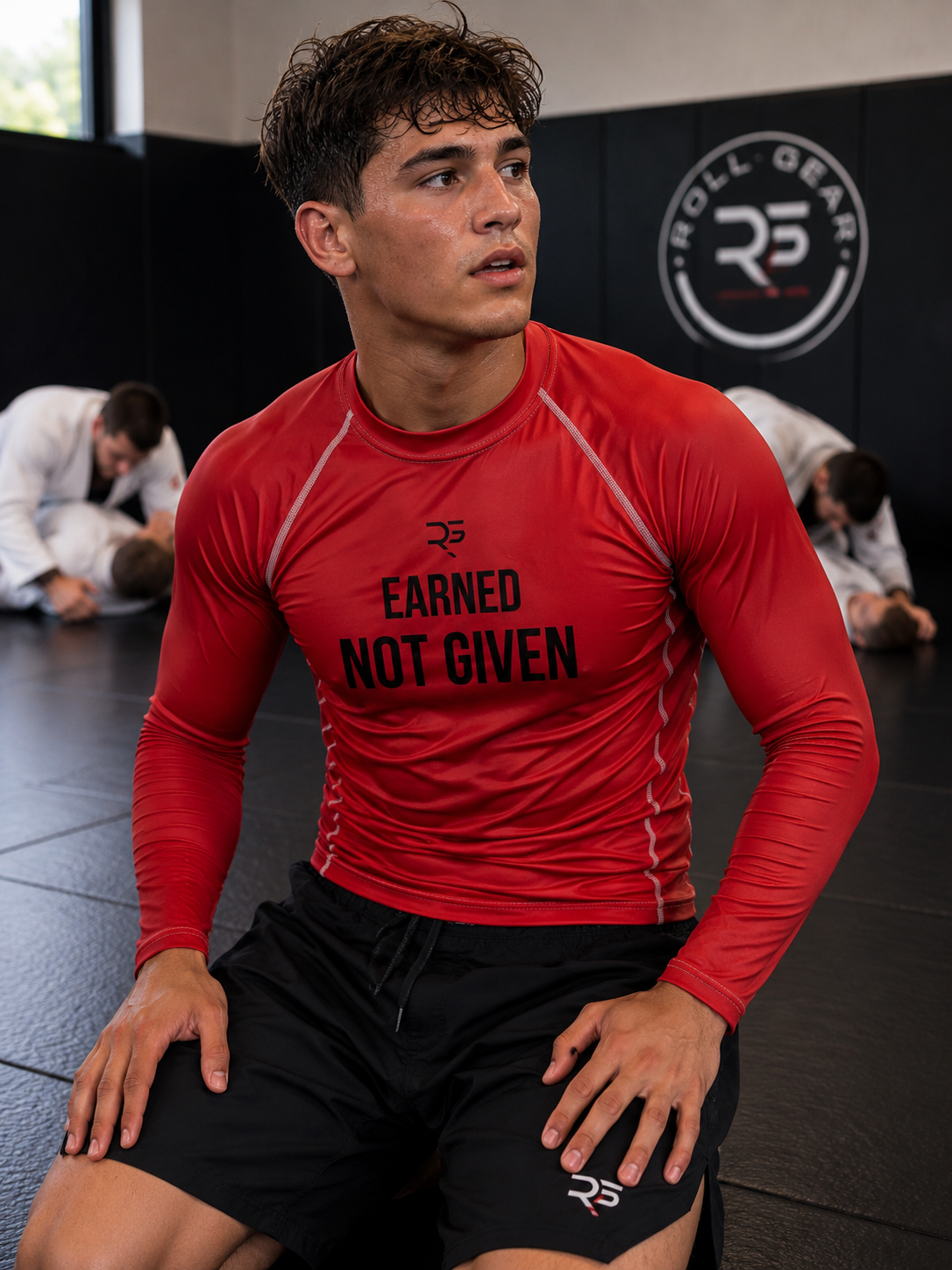 Roll Gear Excuses Don’t Burn Calories Rash Guard – Red – Men’s, worn seated on the mat during class.