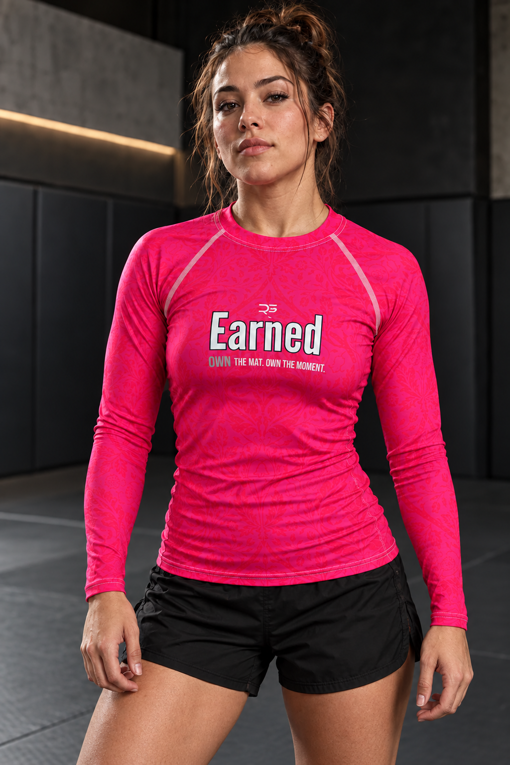Roll Gear Earned Not Given Youth Long Sleeve Rash Guard – Pink, front view, Earned chest graphic.