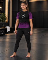 Roll Gear Fade Short Sleeve Rash Guard – Adult, front view on a woman standing on the mat.