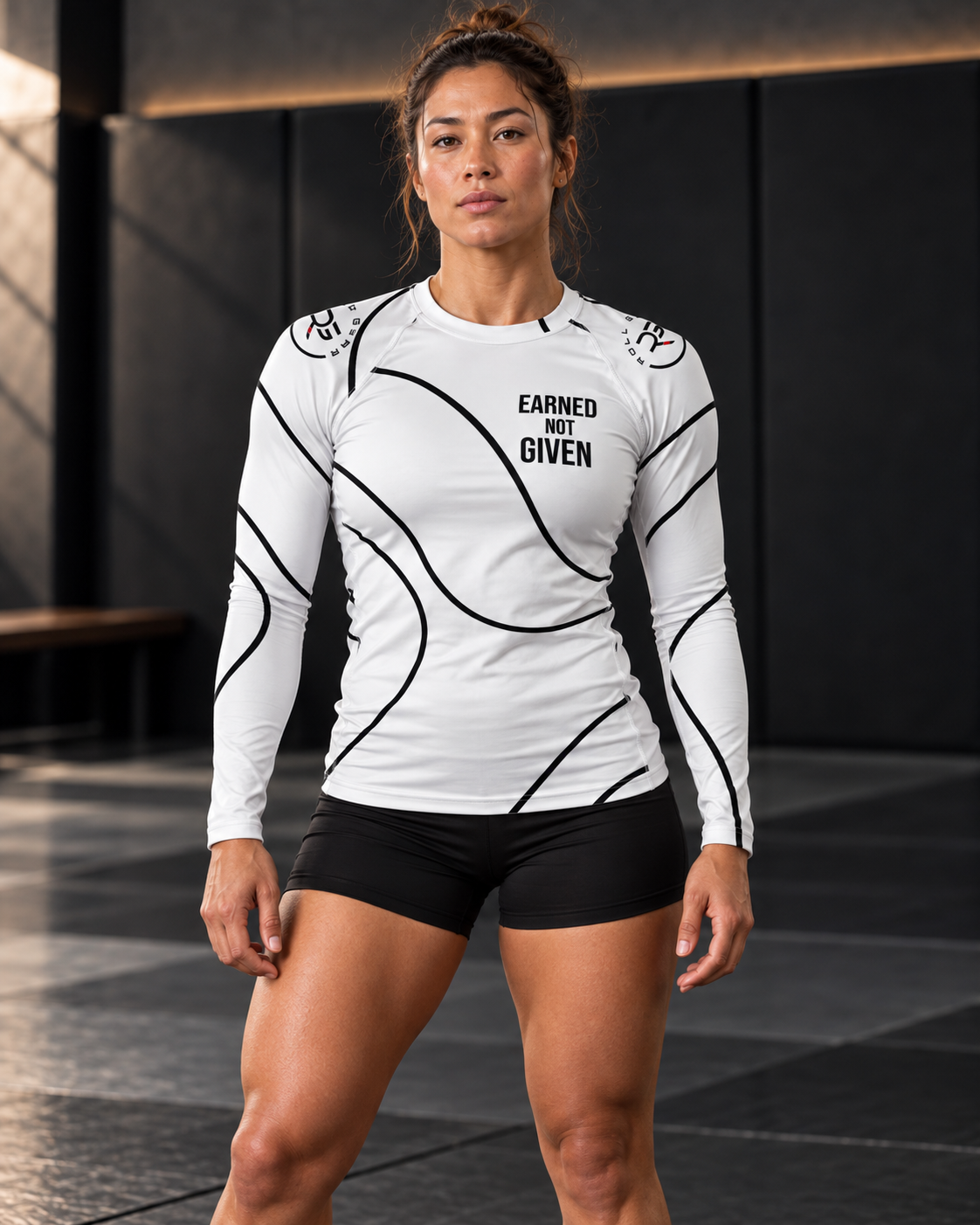 Roll Gear White Swirl Rash Guard – White/Black – Women’s, front view on a woman standing on the mat.