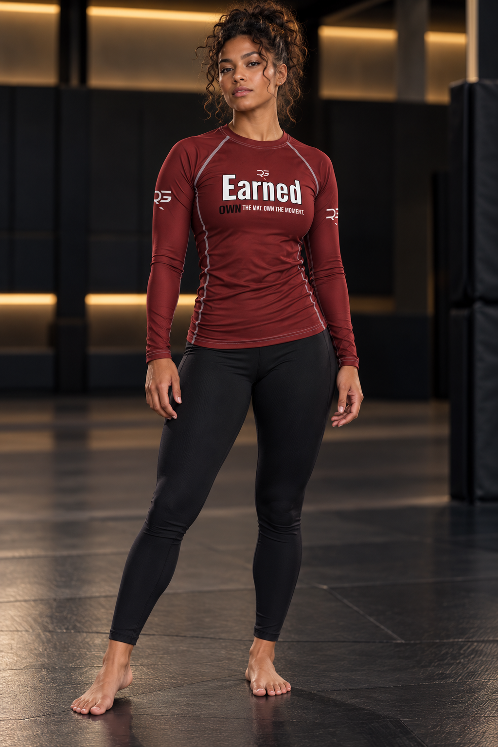 Roll Gear Earned Not Given Long Sleeve Rash Guard – Deep Red – Women’s, woman standing on the mat, front view.