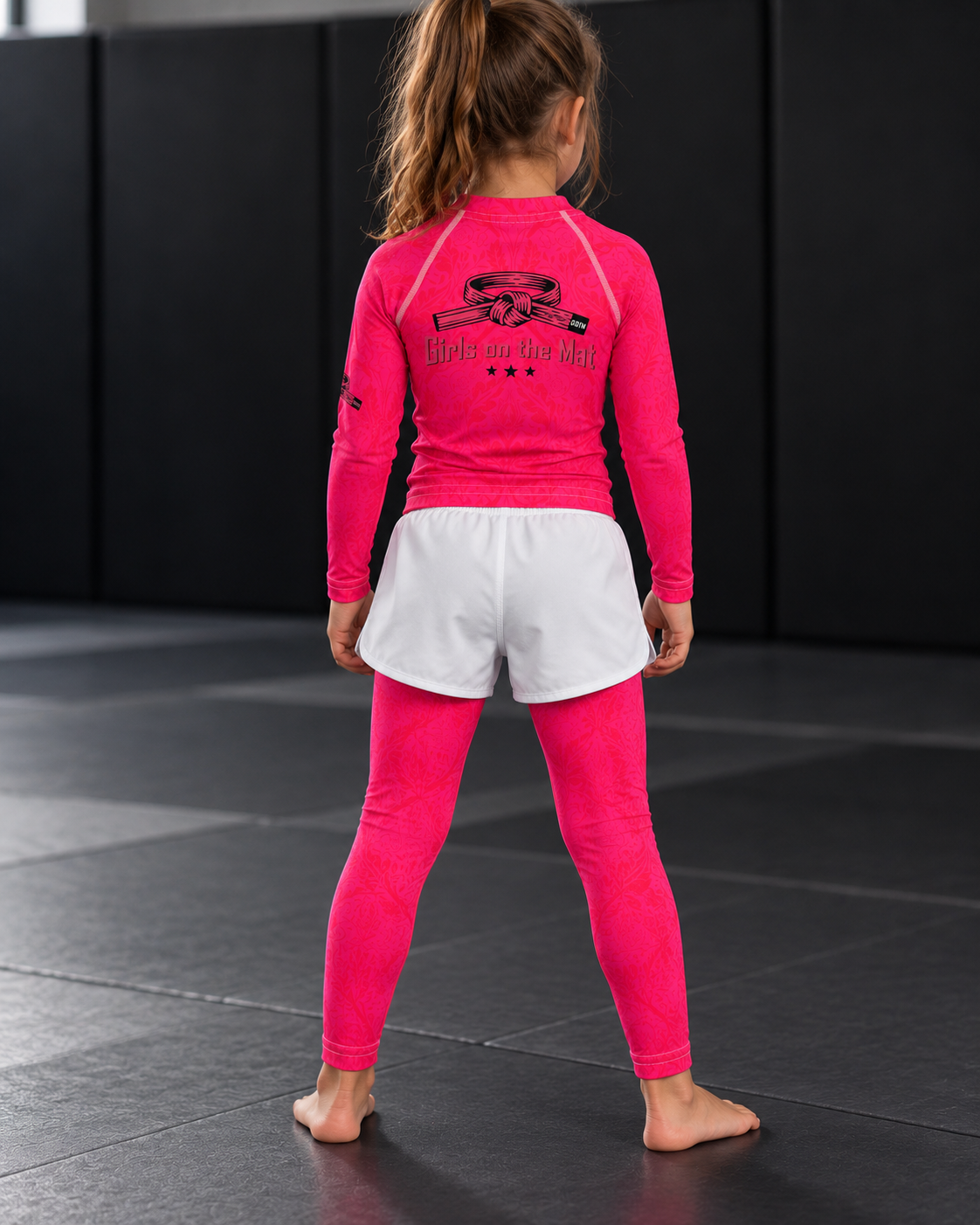 Roll Gear Earned Not Given Long Sleeve Rash Guard – Pink, girl in the matching set, back view.