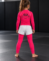 Roll Gear Earned Not Given Long Sleeve Rash Guard – Pink, girl in the matching set, back view.