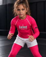 Roll Gear Earned Not Given Long Sleeve Rash Guard – Pink, girl in a ready stance on the mat.