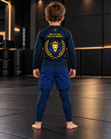 Roll Gear Kids Lion Rash Guard – Future World Champion, boy standing on the mat, back view.