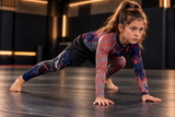 Roll Gear Shadow Dragon Warrior Rash Guard – Youth Long Sleeve, girl in a low lunge on the mat in the matching set.
