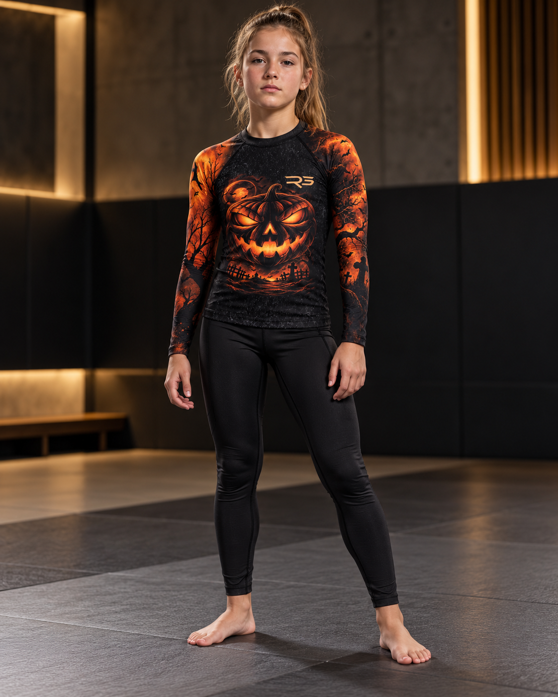 Roll Gear Youth Tap or Treat Long Sleeve Rash Guard, front view, worn by a young female athlete.