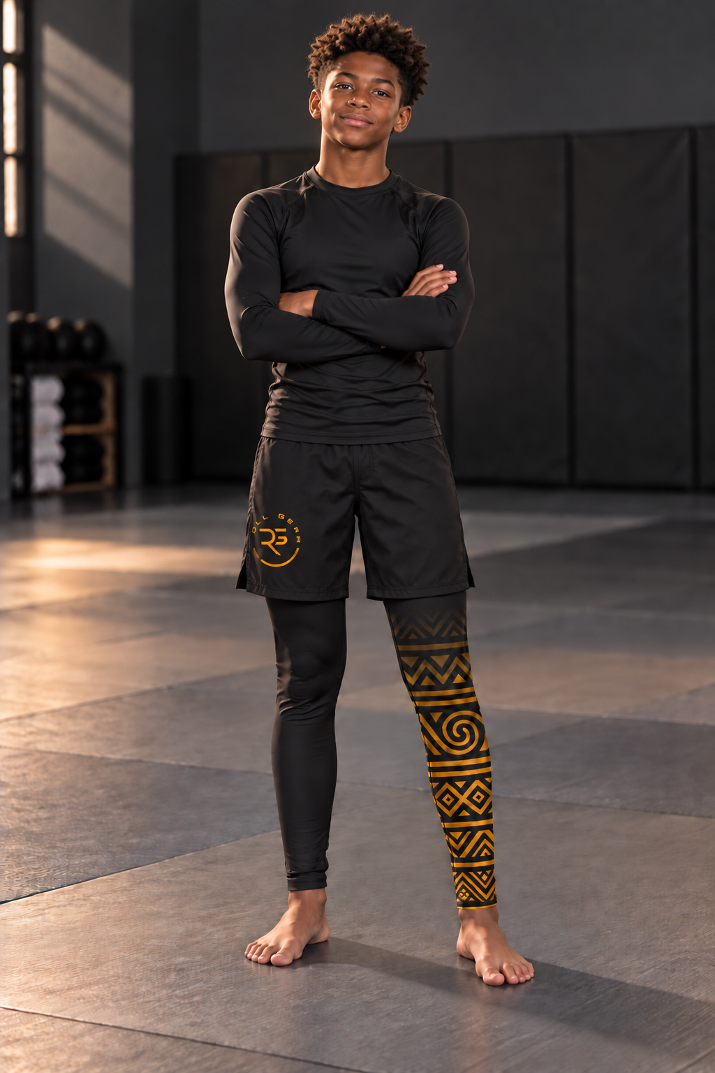 Roll Gear Lion's Pride Spats – Black & Gold – Youth, worn under shorts by a youth athlete on the mat.