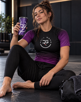 Roll Gear Ranked Series Tumbler – 20oz Stainless Steel – Glossy Purple Finish, held by a woman sitting on the mat.