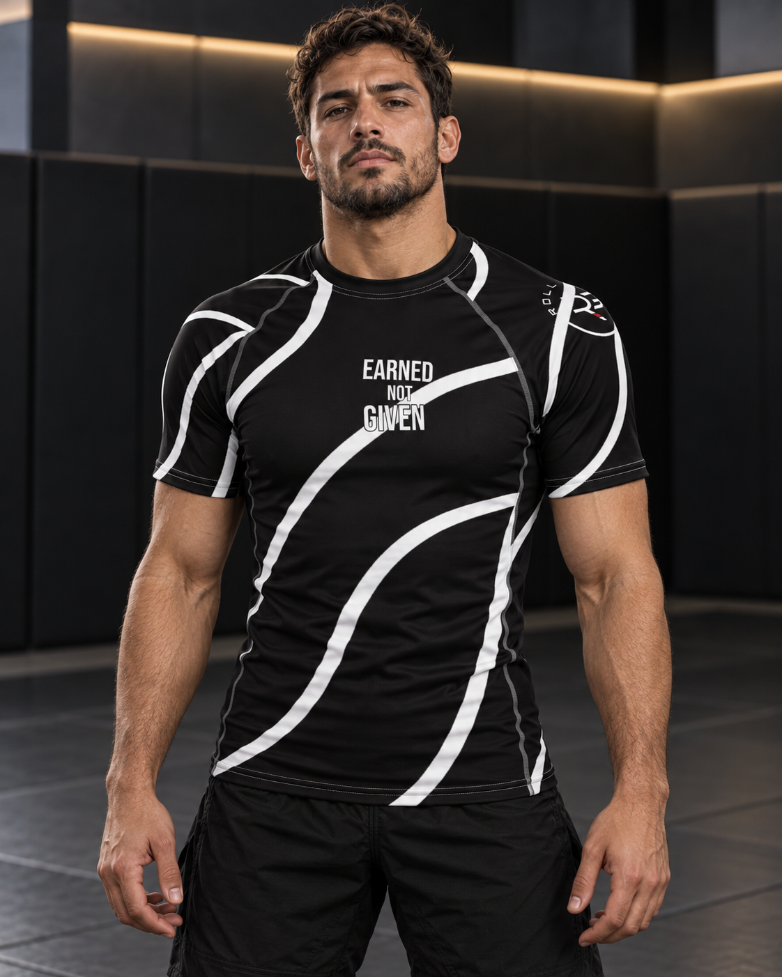 Roll Gear Black Swirl Short Sleeve Rash Guard – Black/White – Adult Unisex, front view on a man, Earned Not Given text.