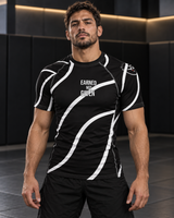 Roll Gear Black Swirl Short Sleeve Rash Guard – Black/White – Adult Unisex, front view on a man, Earned Not Given text.