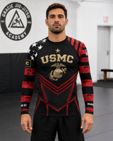 Man wearing a black and red USMC-themed athletic shirt in a martial arts dojo.