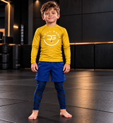 Roll Gear Kids Lion Spats — Future World Champion Collection, boy standing on the mat in a yellow top.