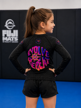 Child wearing a black athletic outfit with colorful text in a martial arts setting