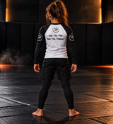 Roll Gear Tap Hype Long Sleeve Rash Guard – Orange & White – Youth, back view on a girl, Own the Mat. Own the Moment. text.