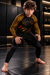 Roll Gear Jaguar Youth BJJ Rash Guard, front view on a boy in a grappling stance, big-cat graphic.