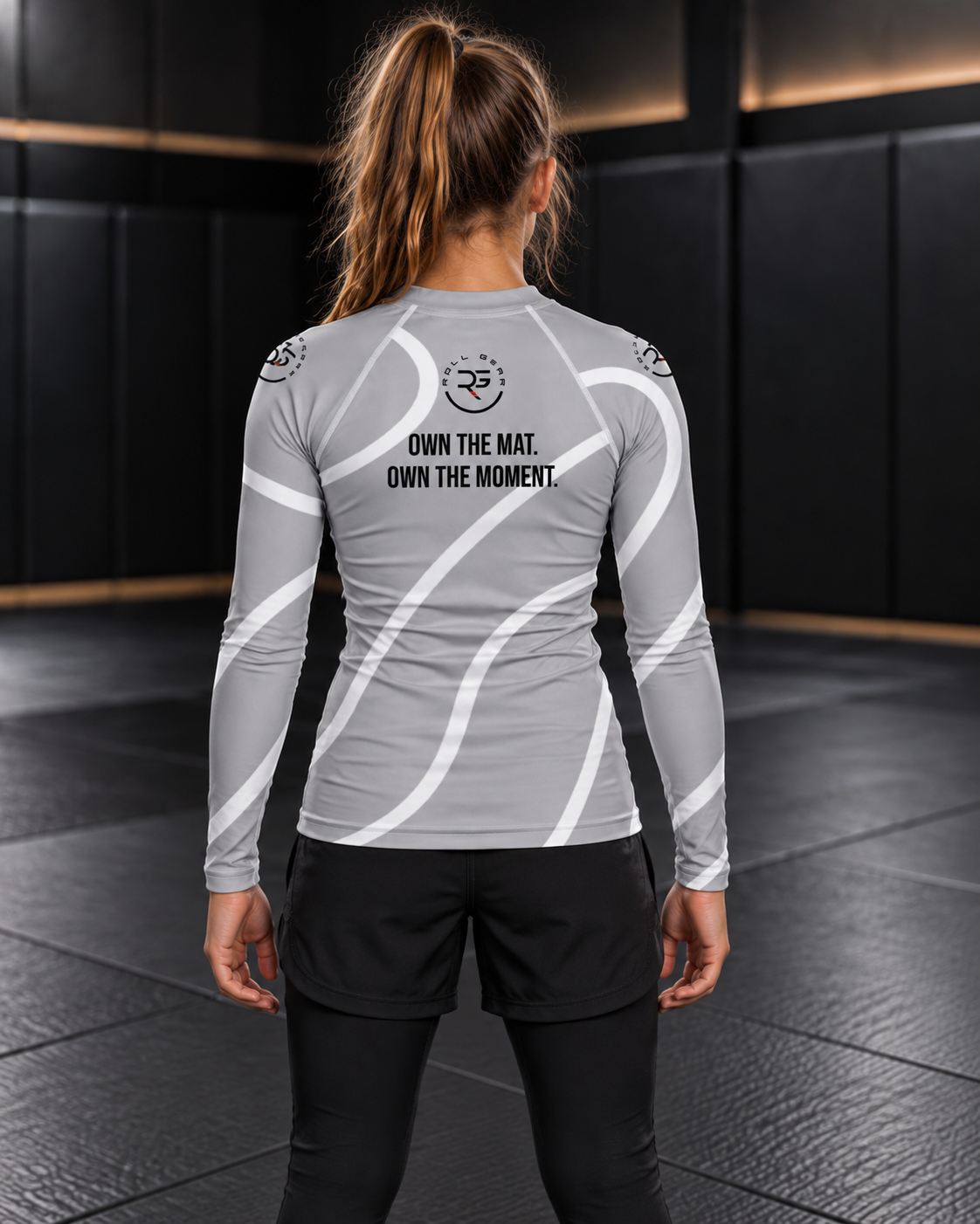 Roll Gear Grey Swirl Rash Guard – Grey/White – Youth, back view on a girl, Own the Mat. Own the Moment. text.