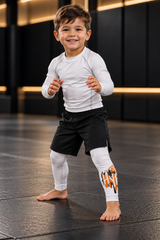 Roll Gear Tap Hype Spats – Orange & White – Kids, front view on a smiling young boy.