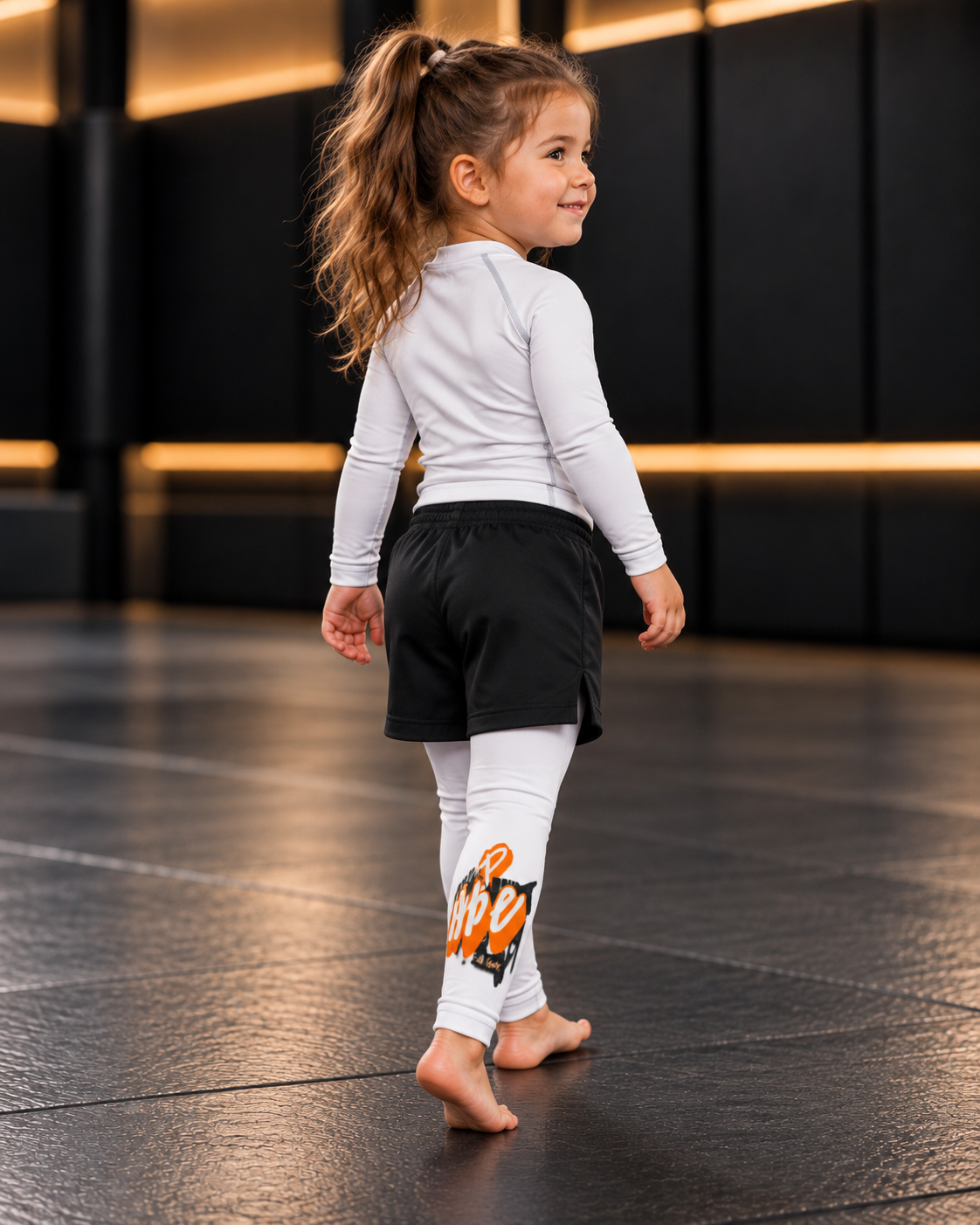 Roll Gear Tap Hype Spats – Orange & White – Kids, young girl looking back over her shoulder.