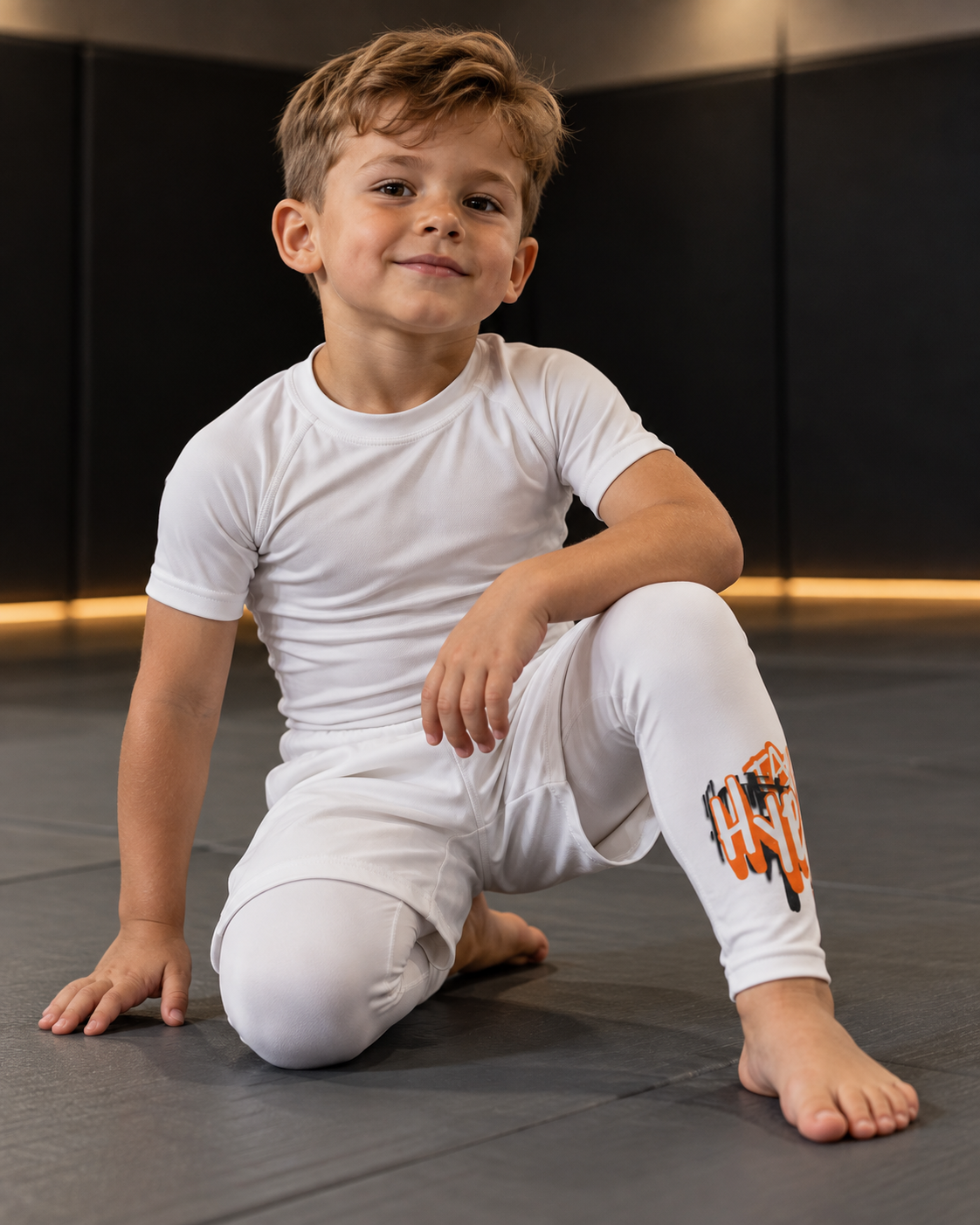 Roll Gear Tap Hype Spats – Orange & White – Kids, young boy sitting on the mat.