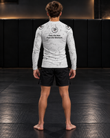 Roll Gear Kids Long Sleeve Rash Guard with White Lines, back view on a teen boy, Own the Mat. Own the Moment. text.