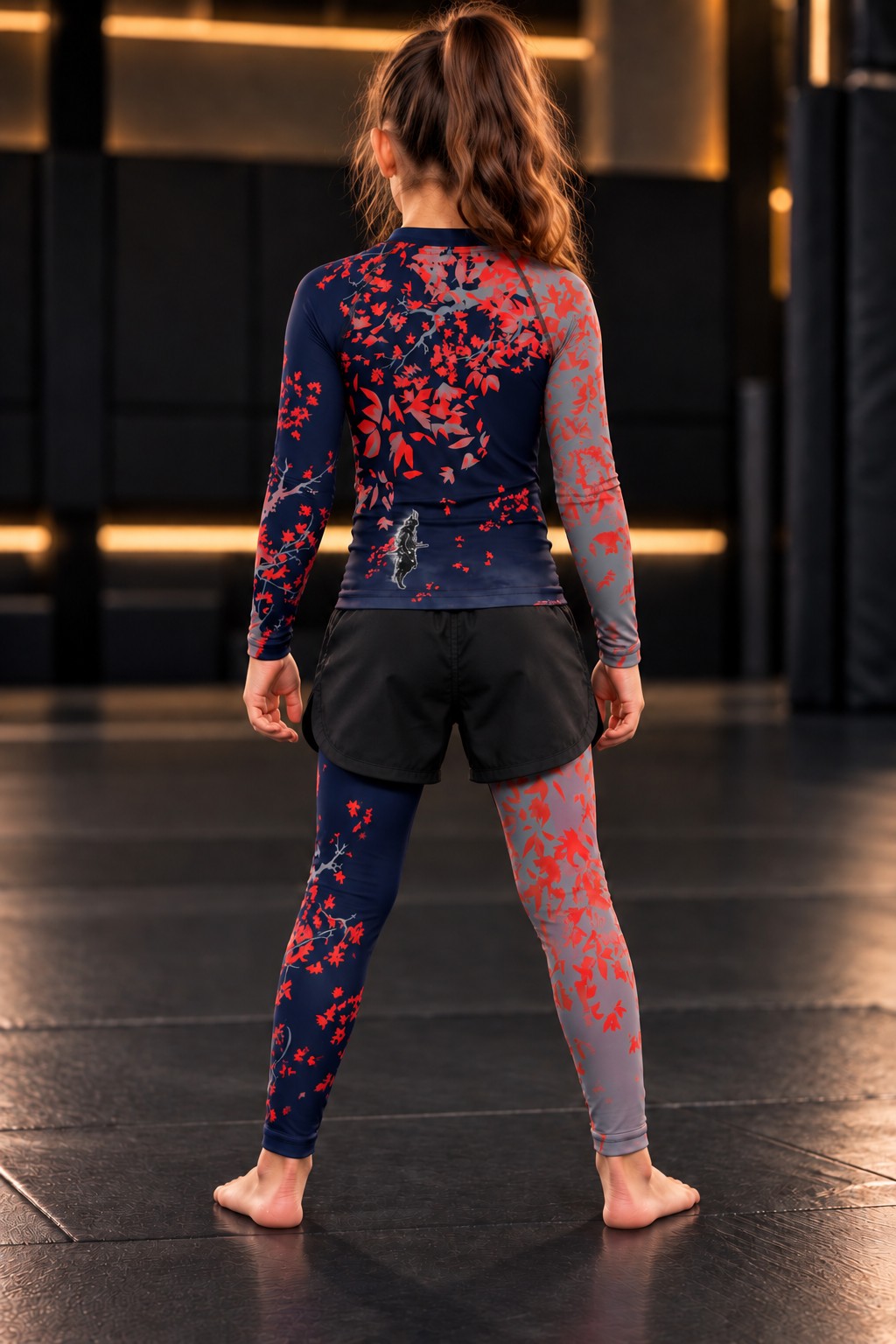 Roll Gear Shadow Dragon Warrior Rash Guard – Youth Long Sleeve, back view on a girl standing on the mat.
