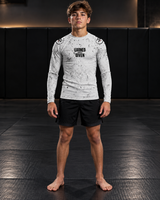 Roll Gear Kids Long Sleeve Rash Guard with White Lines, front view on a teen boy, Earned Not Given graphic.