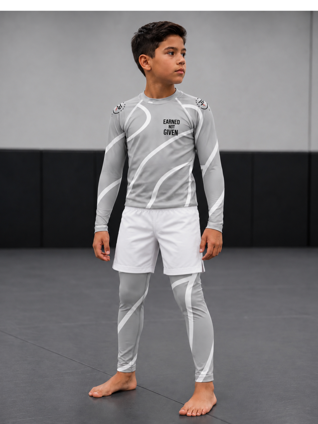 Roll Gear Grey Swirl Long Sleeve Rash Guard – Grey/White – Kids, worn with matching spats by a boy on the mat.