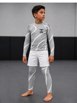 Roll Gear Grey Swirl Long Sleeve Rash Guard – Grey/White – Kids, worn with matching spats by a boy on the mat.