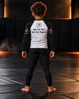 Roll Gear Tap Hype Long Sleeve Rash Guard – Orange & White – Kids, back view on a boy, Own the Mat. Own the Moment. text.
