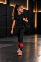 Roll Gear Black Fade Training Spats – Black/Grey – Kids, young girl walking with a gym bag.