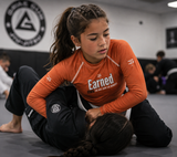 Roll Gear Earned Not Given Long Sleeve Rash Guard - Burnt Orange, Kids, lifestyle photo (girl's fit).