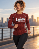 Roll Gear Earned Not Given Long Sleeve Rash Guard – Deep Red – Women’s, woman jogging along a waterfront at sunset.