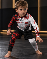 Roll Gear Shadow Dragon Warrior Rash Guard – White & Crimson – Kids Long Sleeve, boy in a fighting stance on the mat.