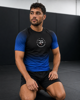 Roll Gear Blue Fade Short Sleeve Rash Guard – black top fading to blue, ranked design for BJJ no-gi training.