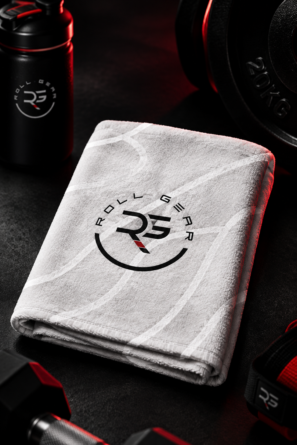 Roll Gear Performance Sweat Towel – Grey, folded with Roll Gear logo next to gym weights.